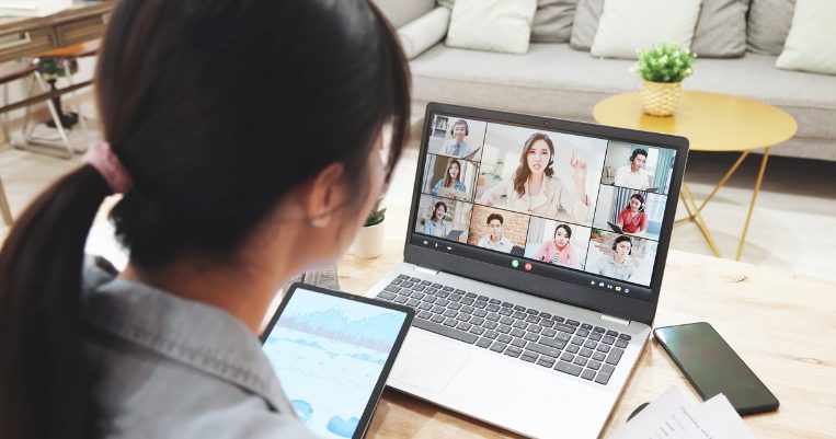 ノートパソコンでオンライン会議に参加している若い女性