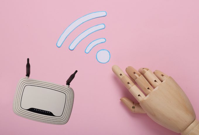 木製の手がwifiマークを指さしている。その横にルーター